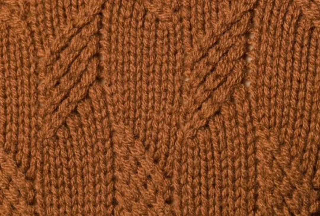 Close-up of a rust-brown cable and leaf-pattern hand knit by lpknit
