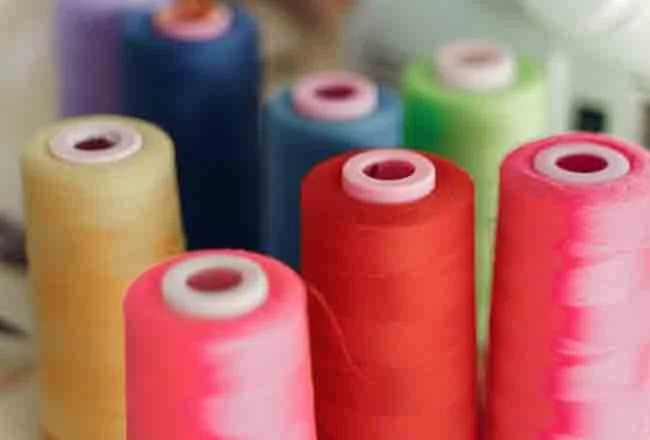 Cones of acrylic knitting yarn in bright colours