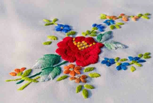 Hand-embroidered floral detail on knitwear by lpknit