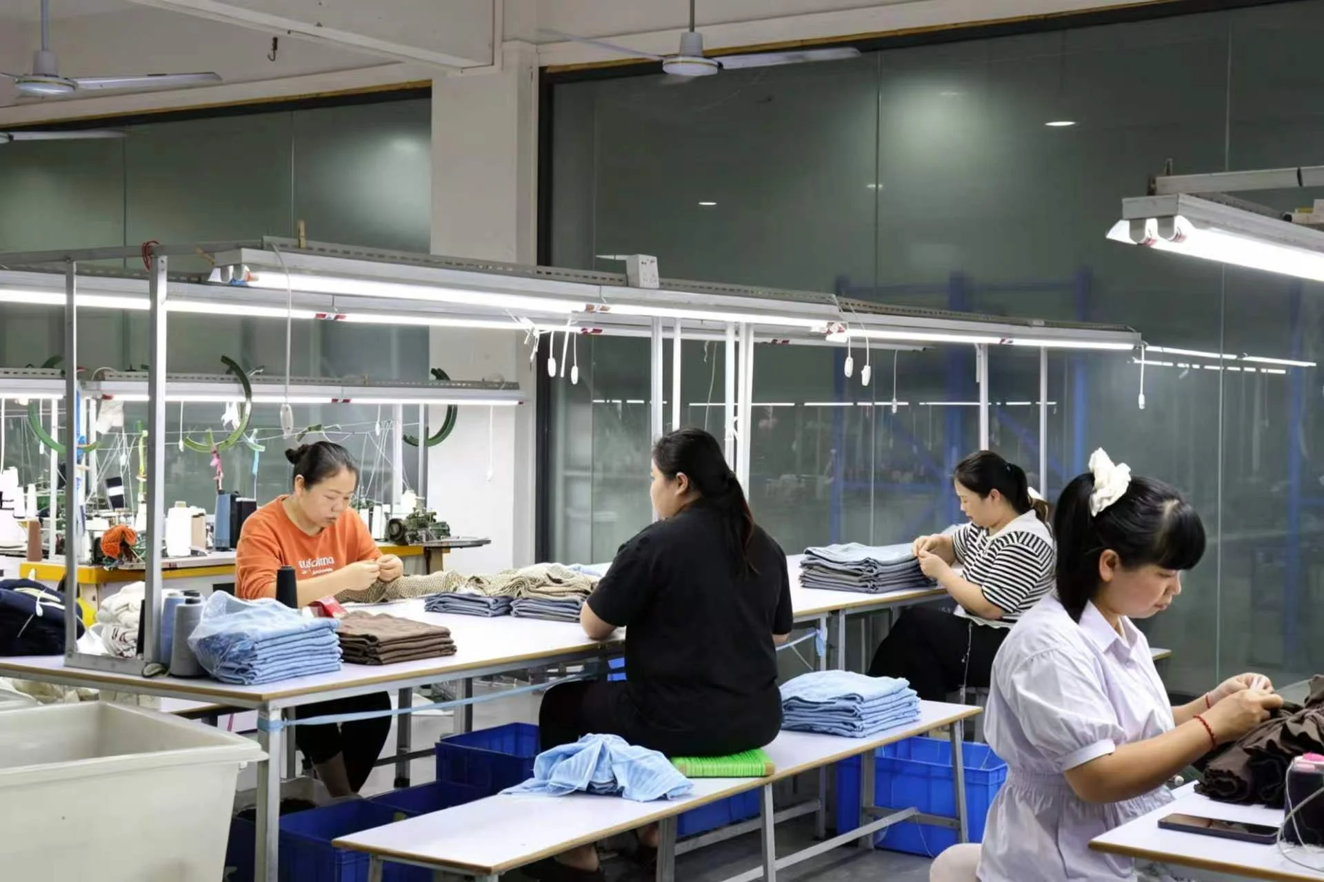 Workers inspecting and finishing knit garments at the lpknit factory
